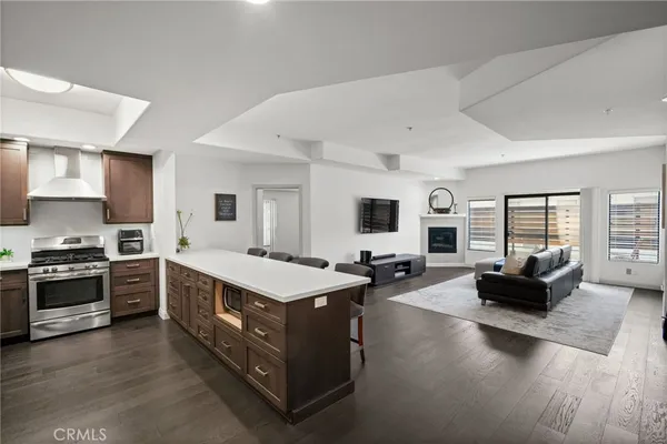 a large white open kitchen with stainless steel appliances kitchen island a stove and a sink