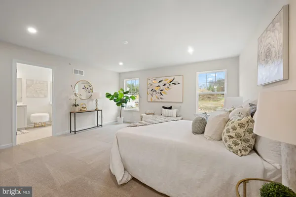 a bedroom with a large bed and potted plant