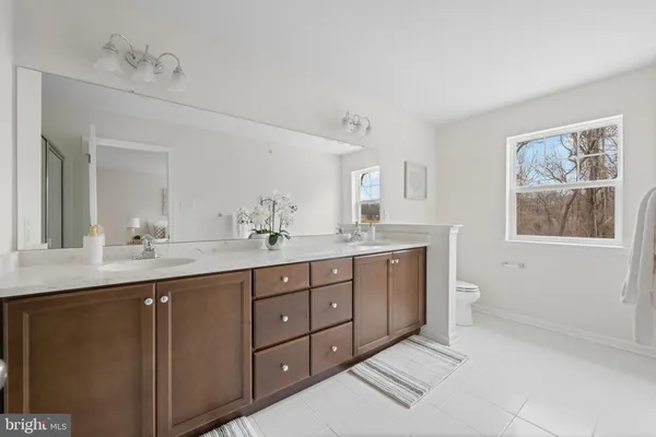 a spacious bathroom with a double vanity sink mirror and window