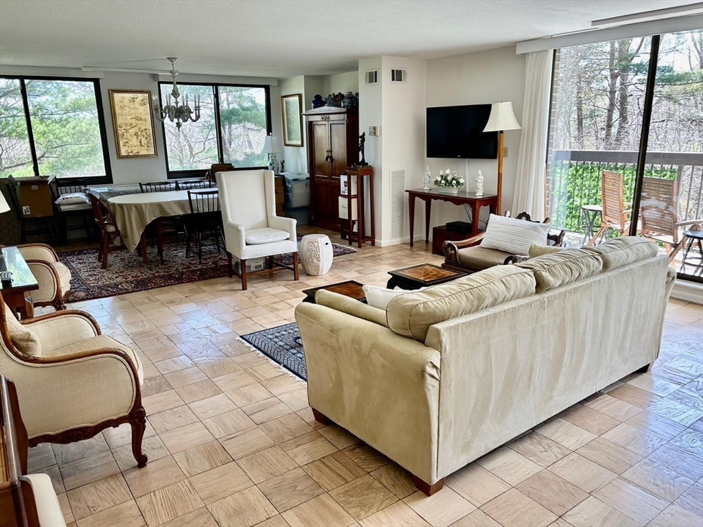 40 Village Road, Unit 309 Middleton, MA 01949 - Photo 4 of 22 a living room with furniture a flat screen tv and a fireplace
