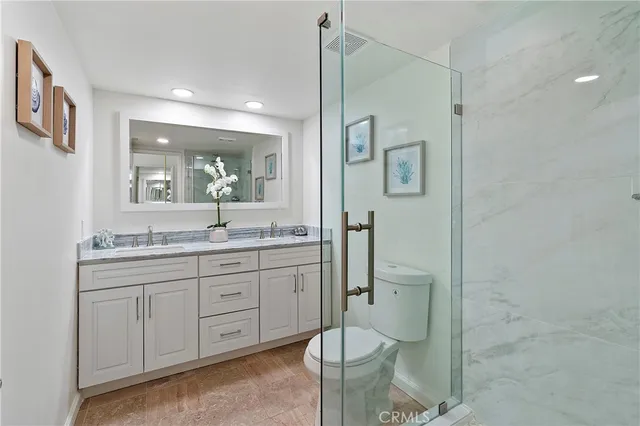 a bathroom with a granite countertop sink toilet and shower