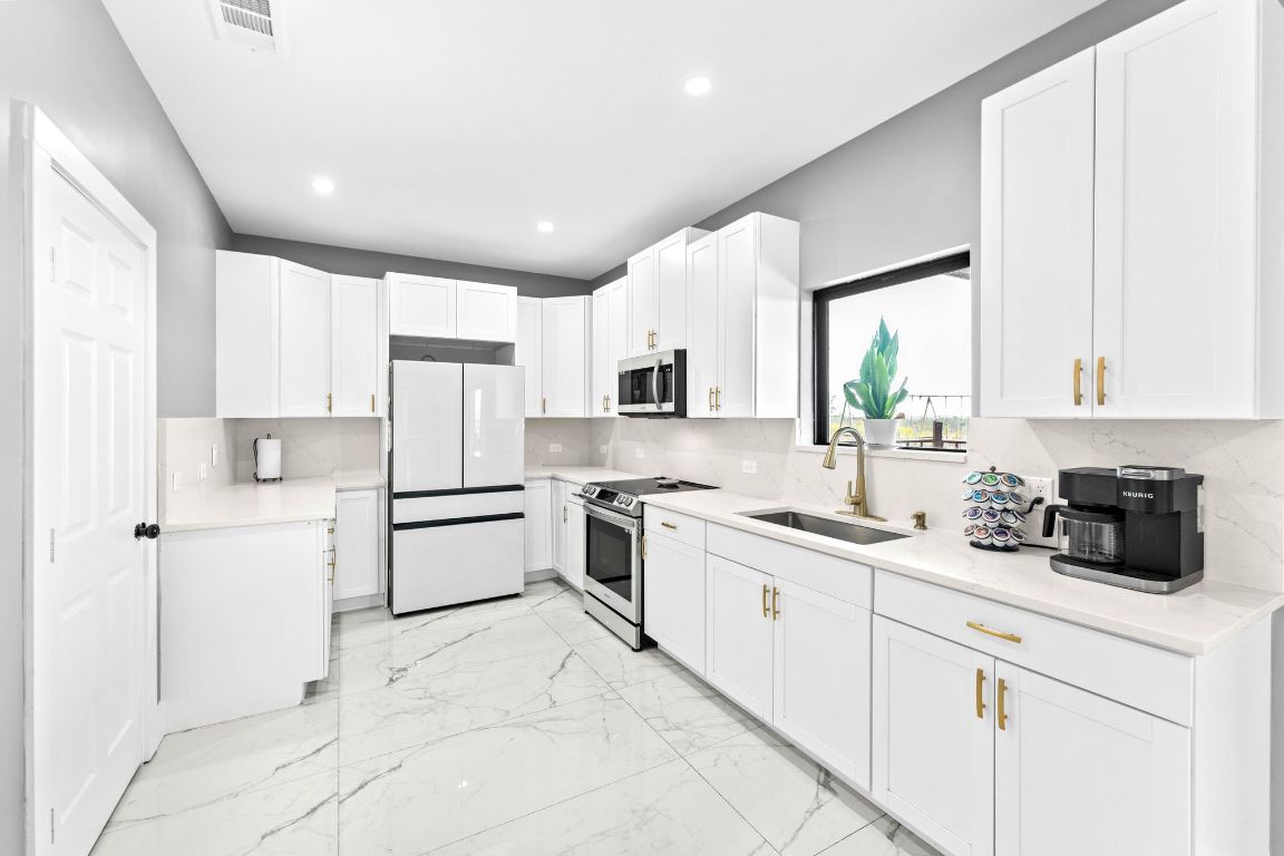 749 El Rey Drive Kyle, TX 78640 - Photo 15 of 40 a kitchen with white cabinets and white appliances