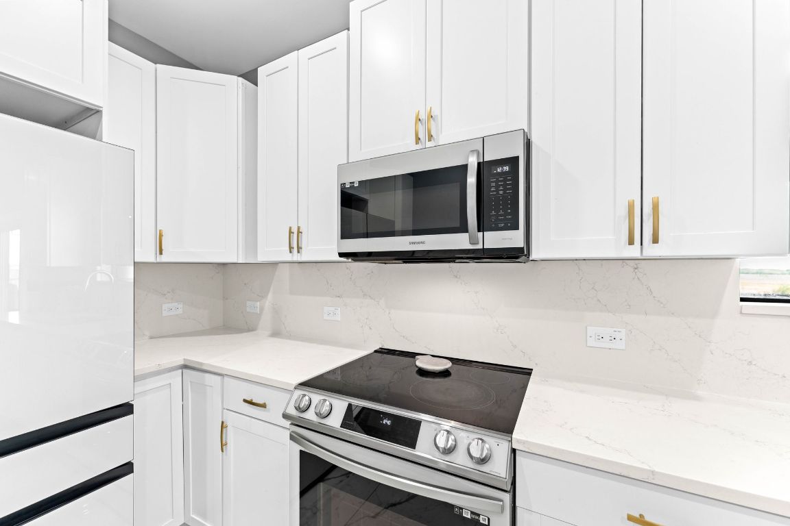 749 El Rey Drive Kyle, TX 78640 - Photo 17 of 40 a kitchen with stainless steel appliances white cabinets and a stove