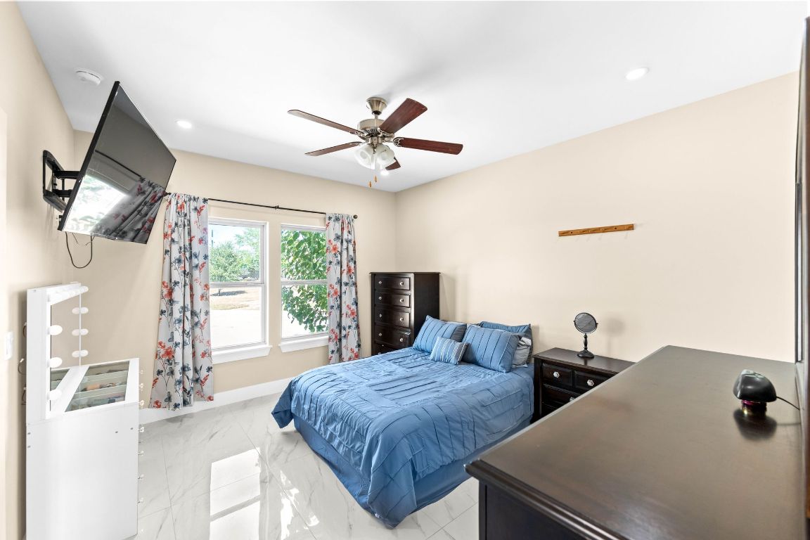 749 El Rey Drive Kyle, TX 78640 - Photo 18 of 40 a bedroom with a bed and a chandelier