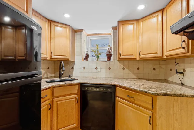 a kitchen with stainless steel appliances granite countertop a sink a stove and a refrigerator