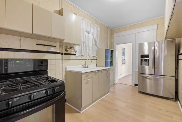 a kitchen with stainless steel appliances a stove a sink and a refrigerator