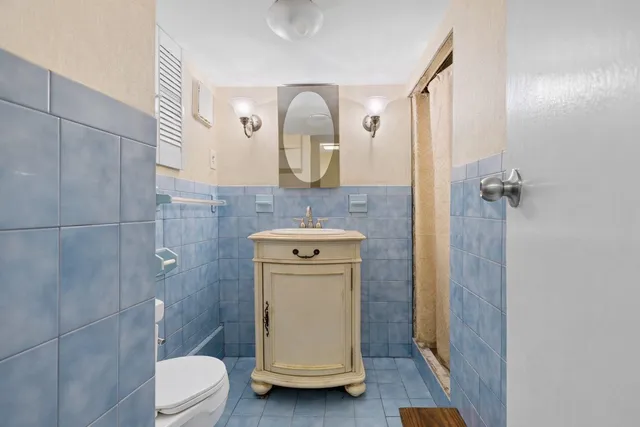a bathroom with a sink a toilet and mirror
