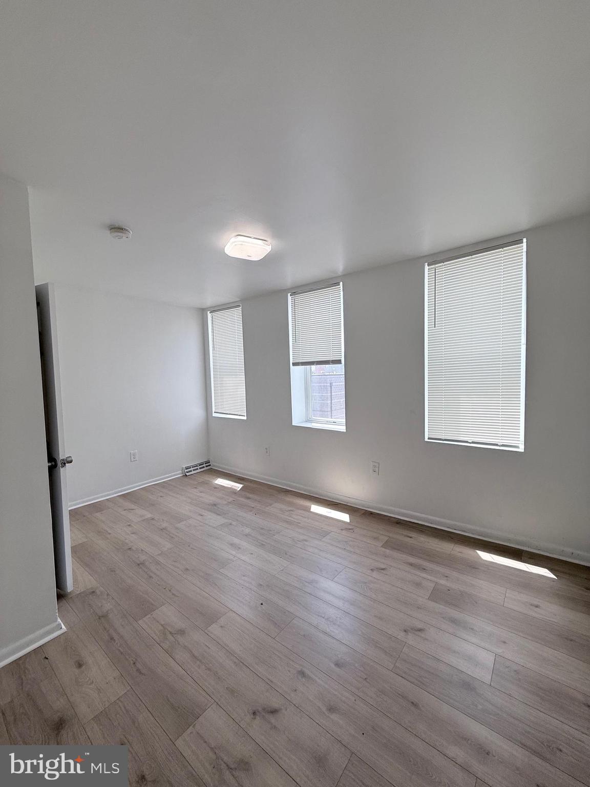 1820 West Fayette Street, Unit 2 Baltimore, MD 21223 - Photo 15 of 26 an empty room with wooden floor and windows