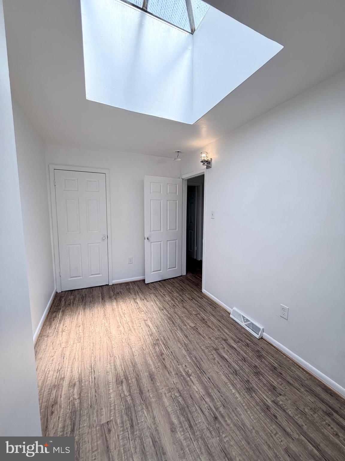 1820 West Fayette Street, Unit 2 Baltimore, MD 21223 - Photo 18 of 26 an empty room with wooden floor and windows