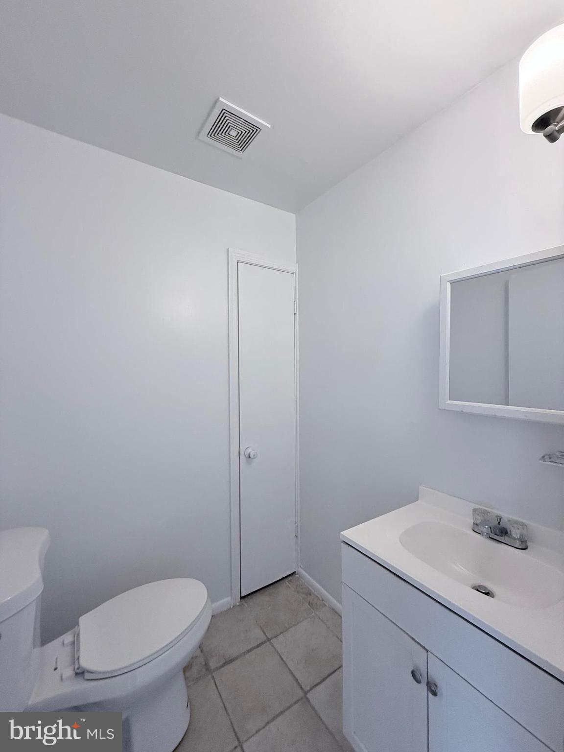 1820 West Fayette Street, Unit 2 Baltimore, MD 21223 - Photo 25 of 26 a bathroom with a toilet a sink and mirror