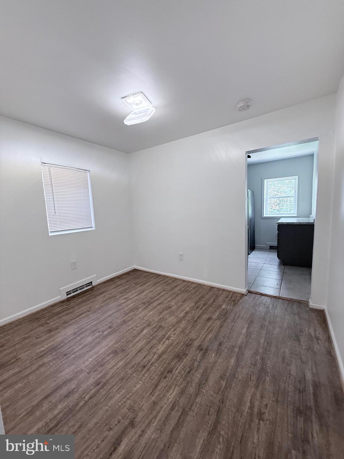 1820 West Fayette Street, Unit 2 Baltimore, MD 21223 - Photo 6 of 26 a view of an empty room with wooden floor and a window