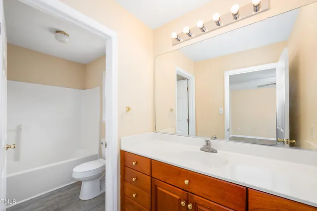 a bathroom with a granite countertop sink a toilet and a bathtub