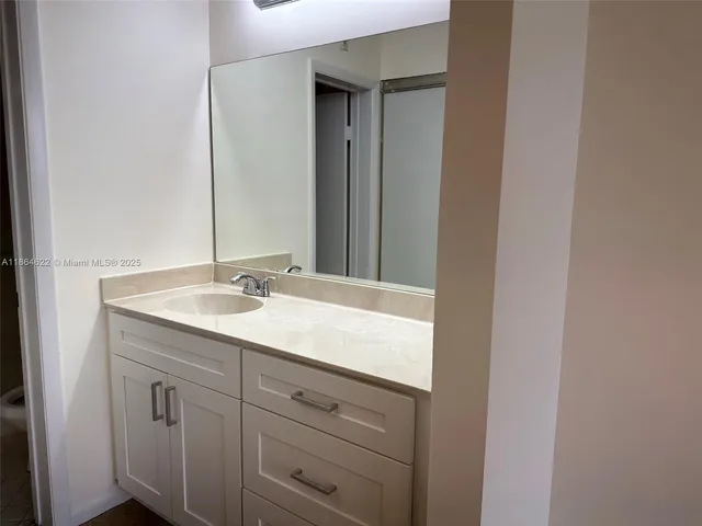 a view of an empty room and chandelier fan