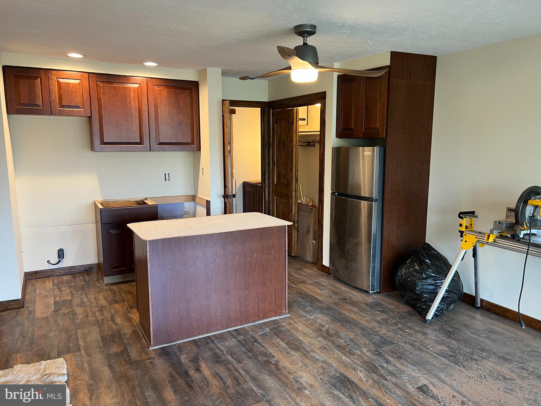 140 The Hill Road, Unit 21B Basye, VA 22810 - Photo 5 of 17 a room with wooden cabinets a sink and a refrigerator