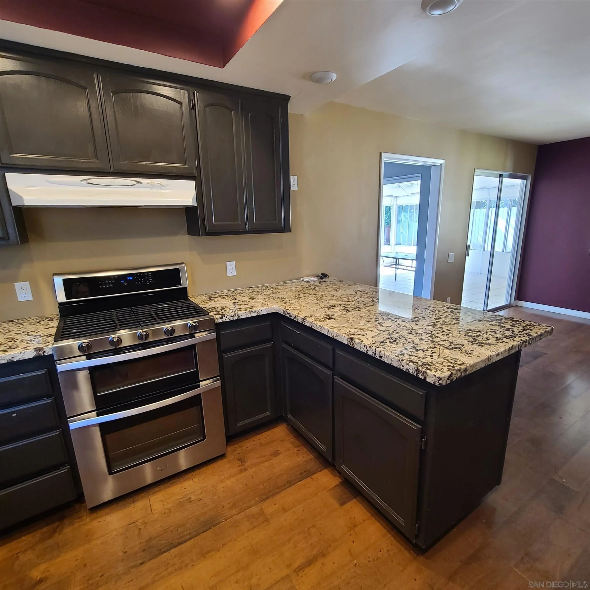 12731 Rios Road San Diego, CA 92128 - Photo 12 of 46 a kitchen with kitchen island granite countertop stainless steel appliances and wooden cabinets