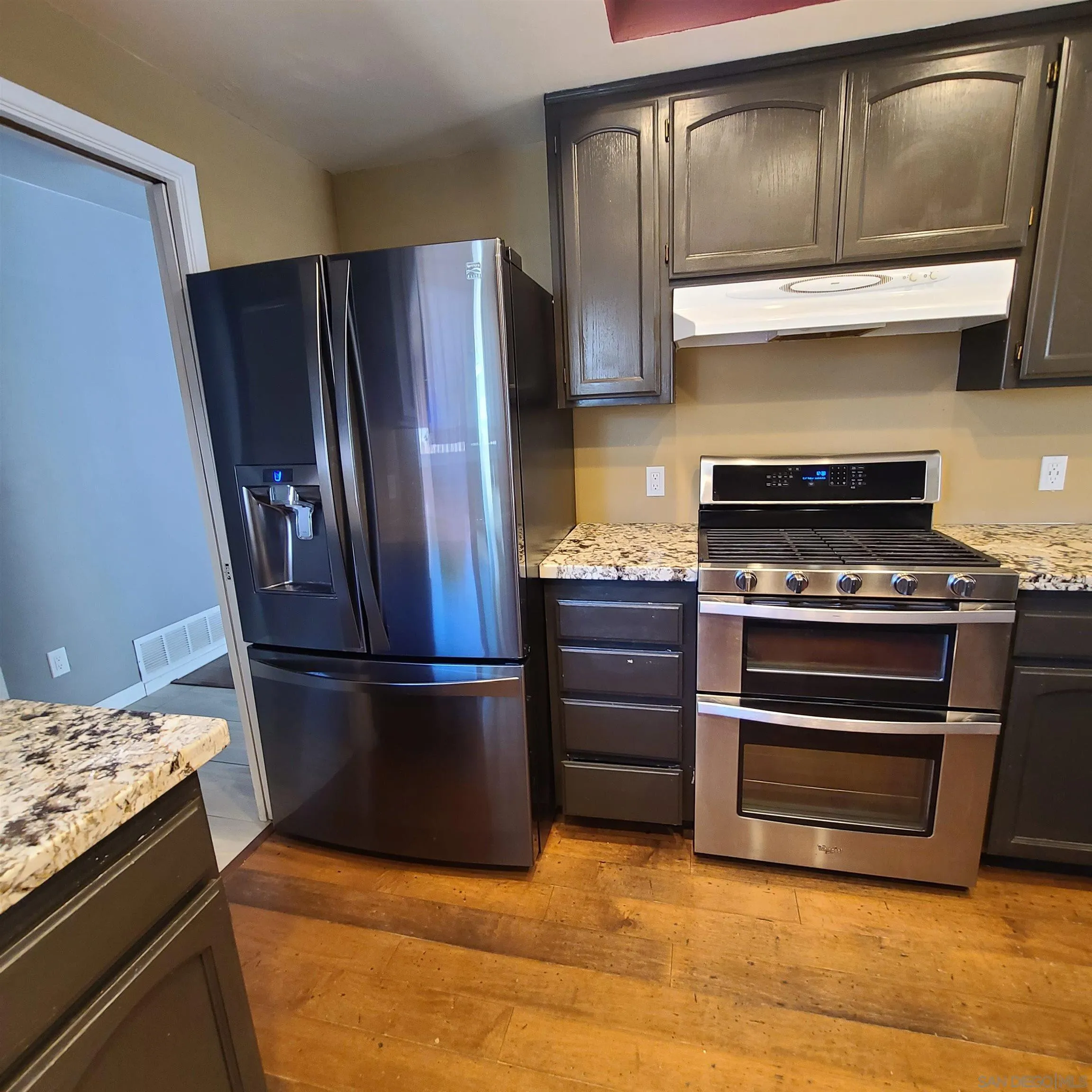 12731 Rios Road San Diego, CA 92128 - Photo 14 of 46 a kitchen with granite countertop stainless steel appliances and wooden cabinets