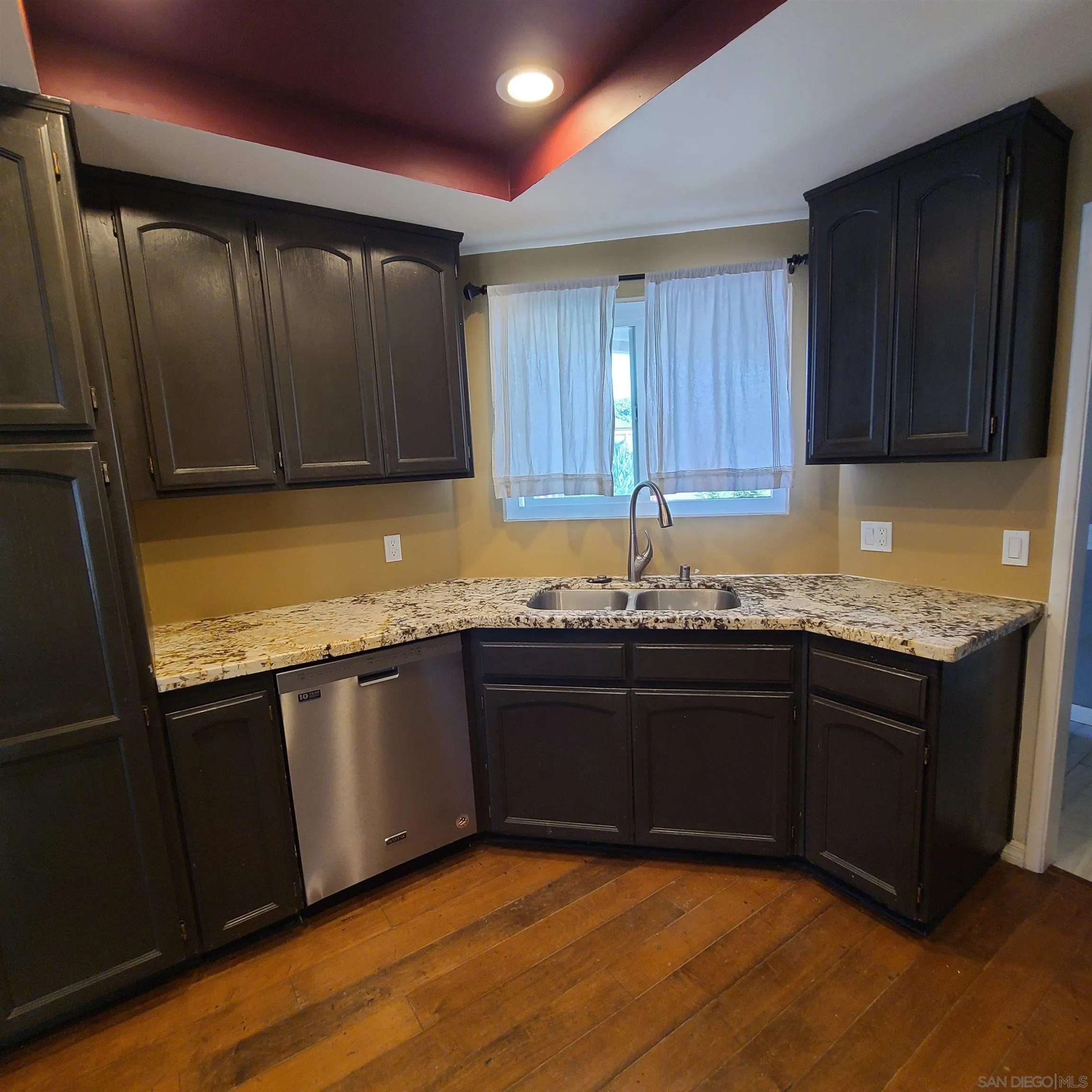12731 Rios Road San Diego, CA 92128 - Photo 15 of 46 a kitchen with granite countertop wooden cabinets a sink and dishwasher
