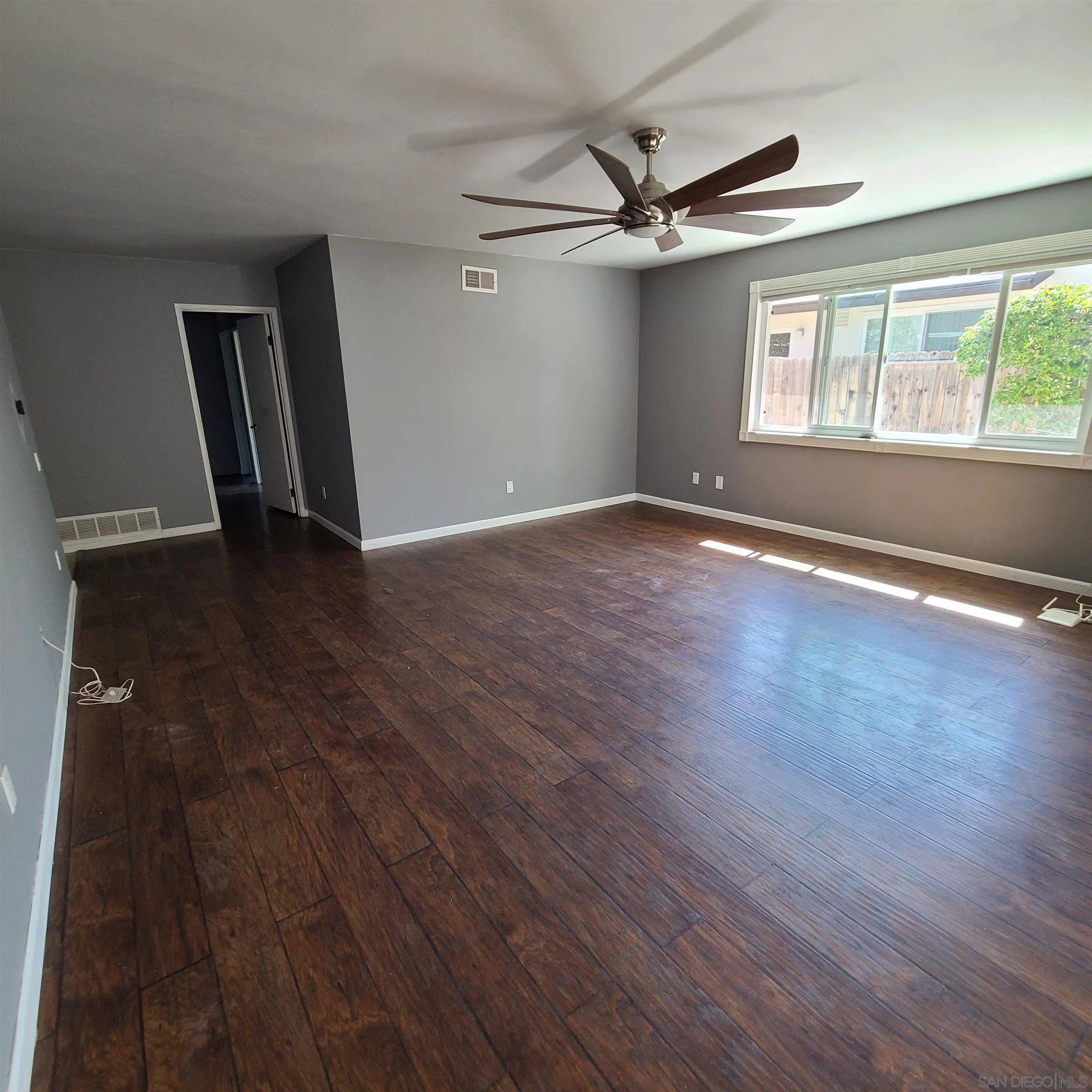 12731 Rios Road San Diego, CA 92128 - Photo 26 of 46 an empty room with wooden floor fan and windows
