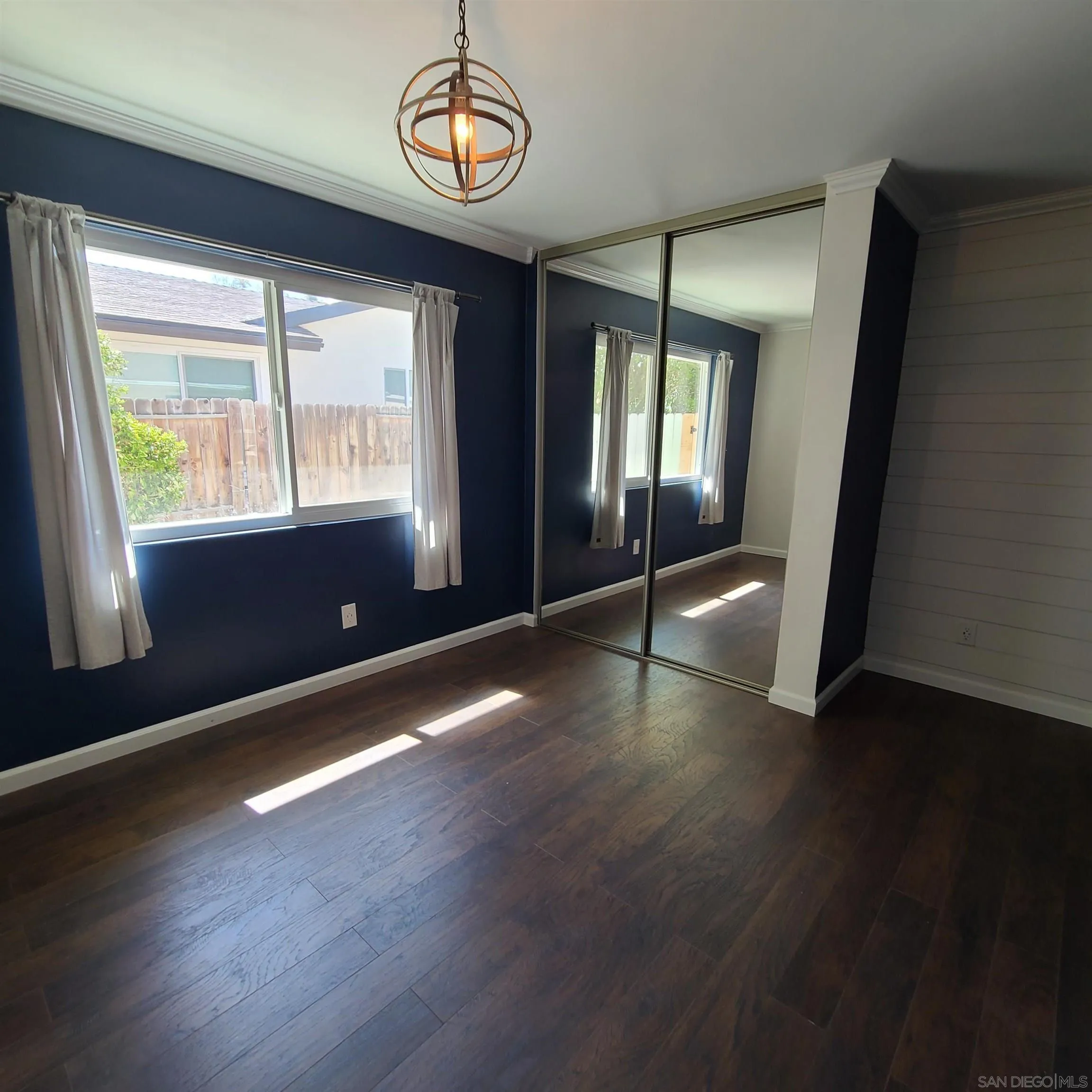 12731 Rios Road San Diego, CA 92128 - Photo 40 of 46 an empty room with wooden floor and windows