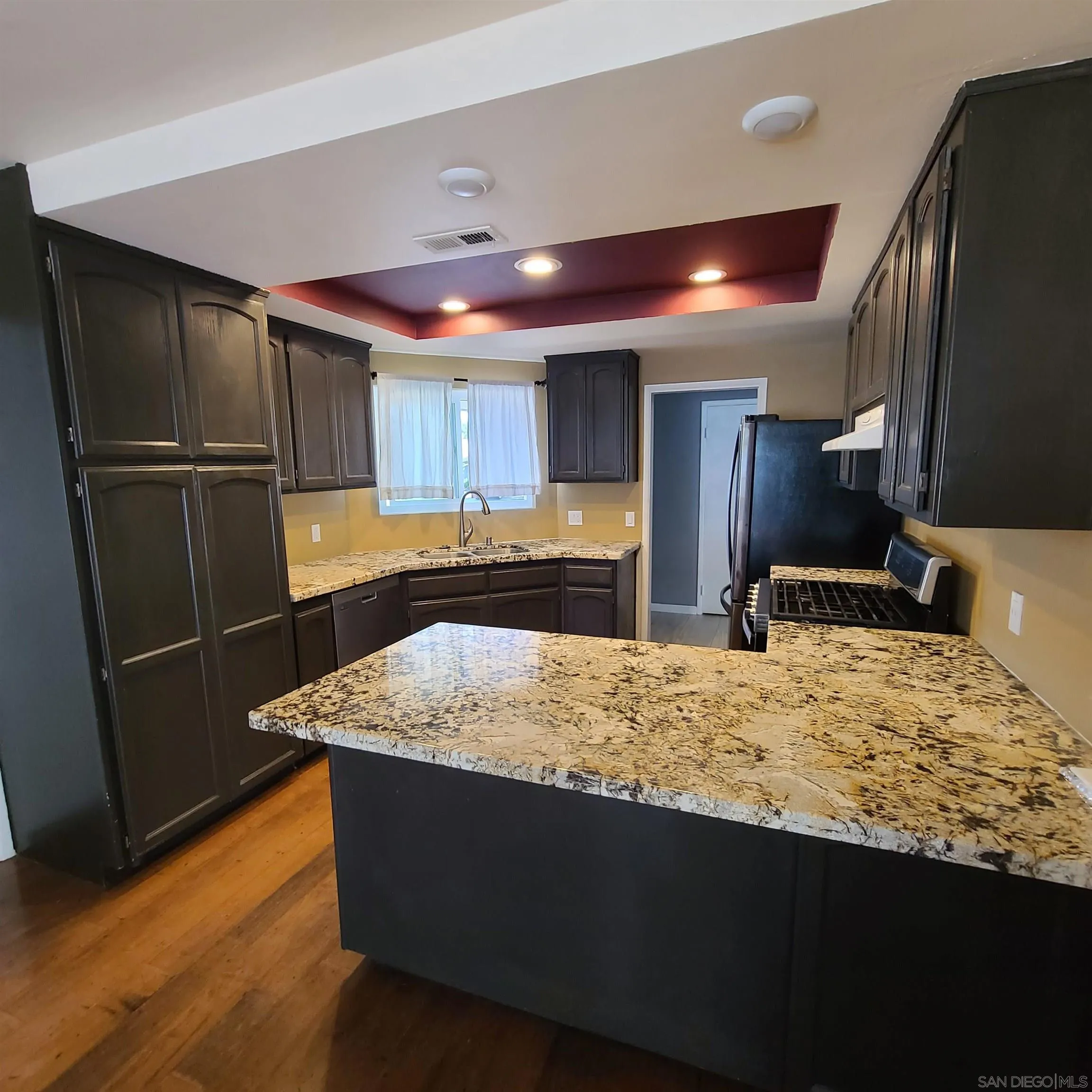 12731 Rios Road San Diego, CA 92128 - Photo 10 of 46 a kitchen with kitchen island a counter top space cabinets and stainless steel appliances