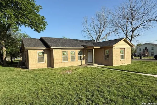 a front view of a house with yard and trees