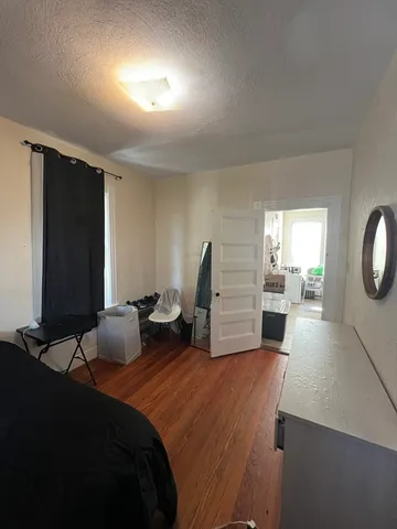 a bedroom with a bed and a flat tv screen on the dresser