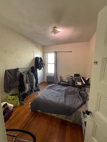 a bed sitting in a bedroom next to a window