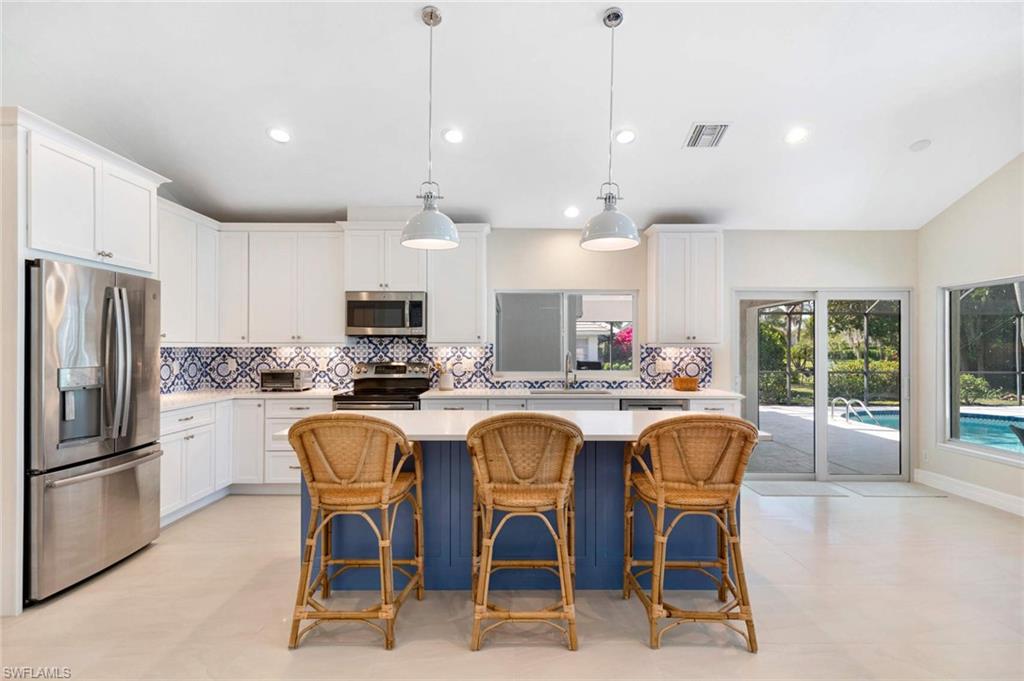 a kitchen with granite countertop a center island a sink stainless steel appliances and cabinets