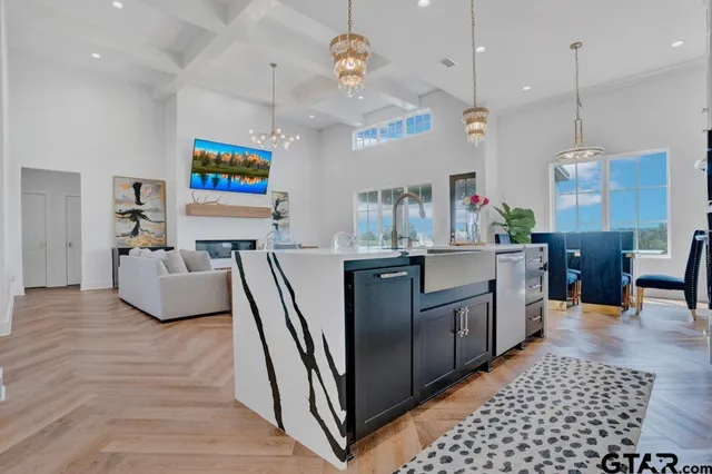 a kitchen with stainless steel appliances granite countertop a sink a stove top oven a chimney and a center island