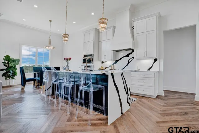a kitchen with stainless steel appliances kitchen island granite countertop a sink a counter space and cabinets
