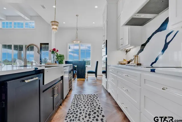 a kitchen with kitchen island granite countertop a sink cabinets and stainless steel appliances
