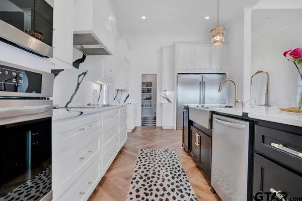 a kitchen with stainless steel appliances kitchen island granite countertop a stove a sink and a refrigerator