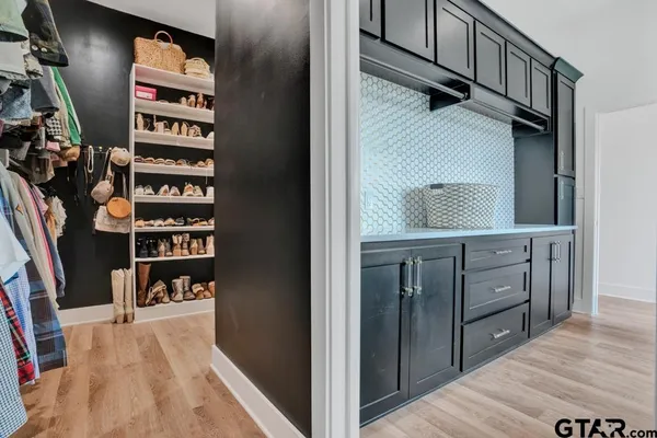 a view of walk in closet with clothes