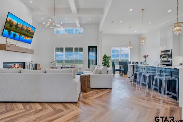 a living room with furniture a dining table and a chandelier