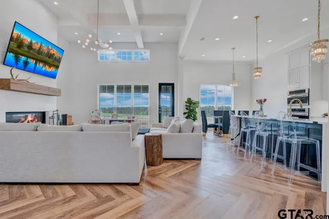 a living room with furniture a dining table and a chandelier