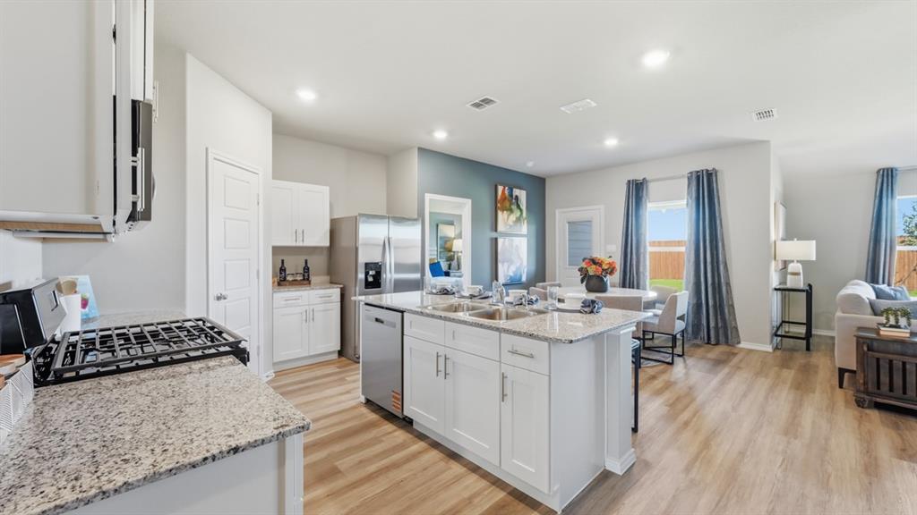 16536 Hudson Pr Way Justin, TX 76247 - Photo 5 of 39 a kitchen with a stove a sink a refrigerator and cabinets