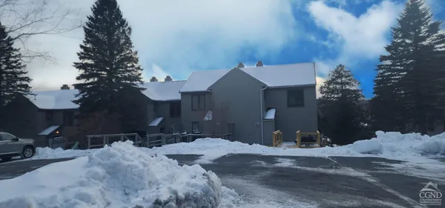 a living room with furniture a flat screen tv and kitchen view