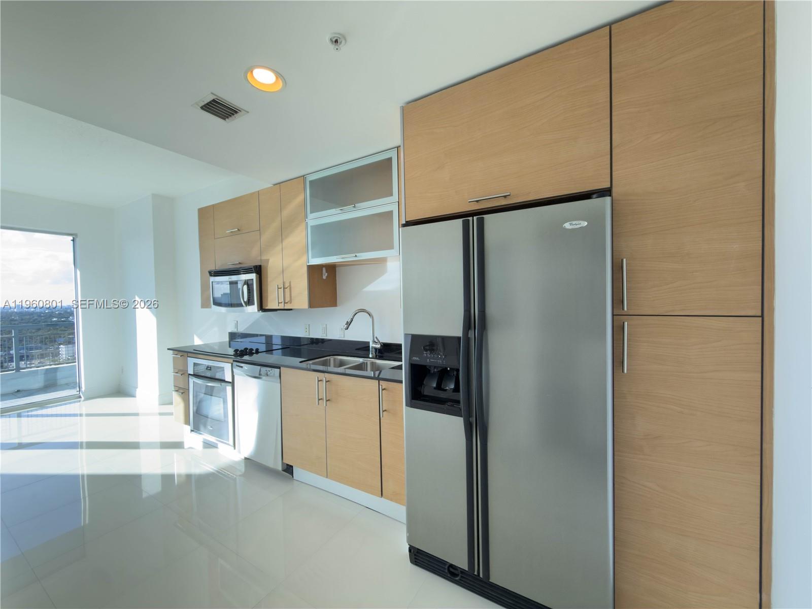 60 Southwest 13th Street, Unit 1605 Miami, FL 33130 - Photo 3 of 30 a kitchen with stainless steel appliances a refrigerator and a stove top oven
