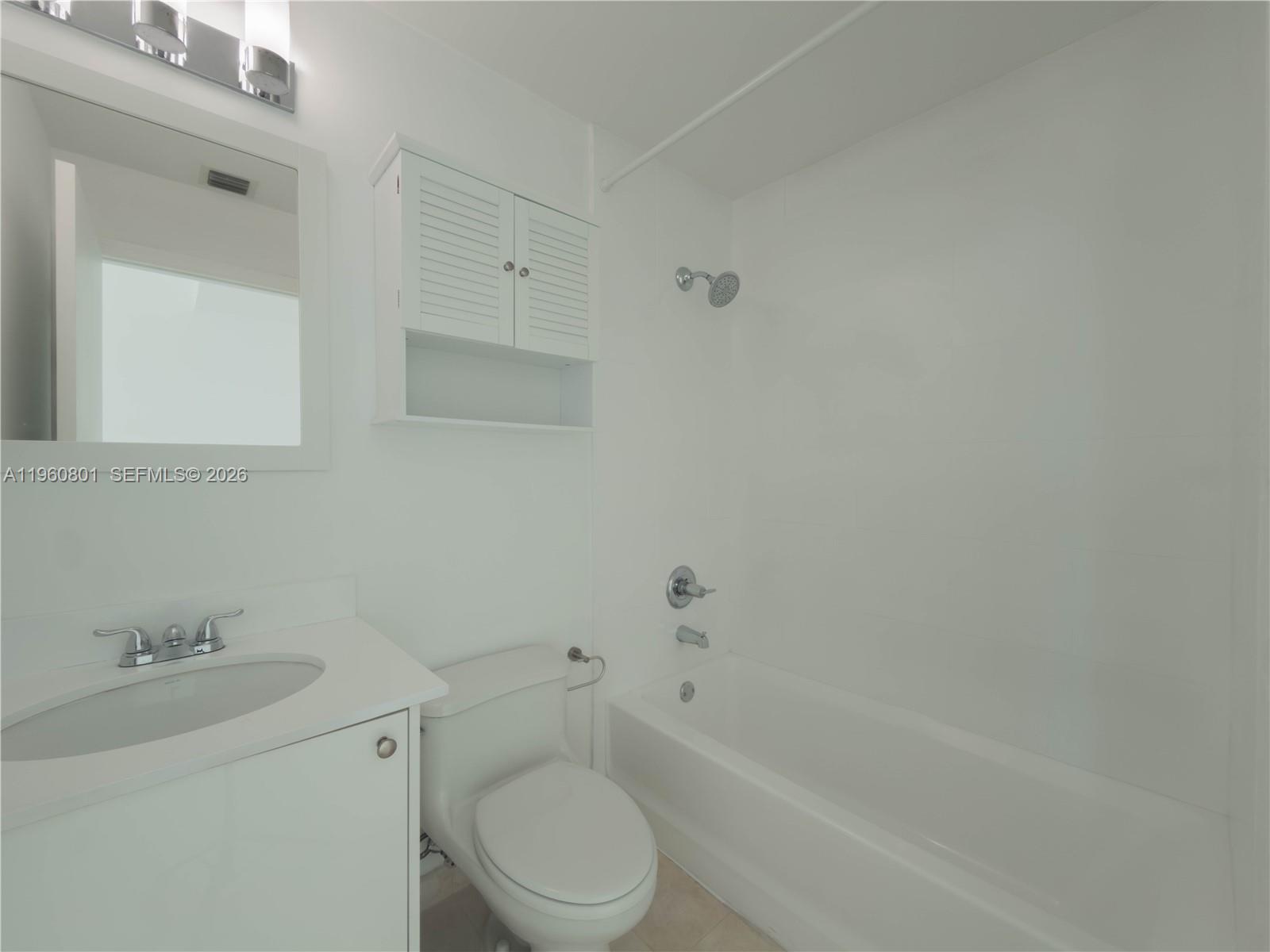 60 Southwest 13th Street, Unit 1605 Miami, FL 33130 - Photo 10 of 30 a bathroom with a toilet a sink a mirror and bathtub