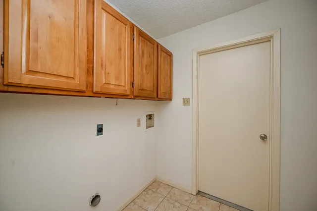 a view of cabinets and utility room with window
