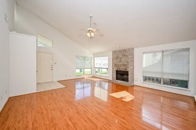an empty room with wooden floor and fireplace