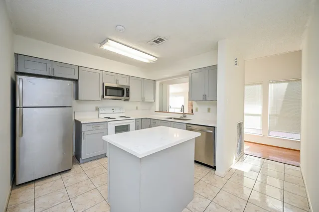 a kitchen with white cabinets and white appliances