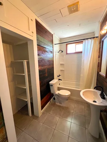 a bathroom with a toilet a sink and shower