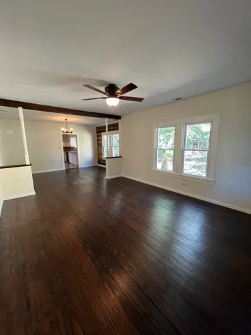a view of a livingroom with wooden floor and a window
