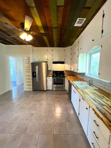 a large kitchen with stainless steel appliances granite countertop a large stove a sink dishwasher and a refrigerator