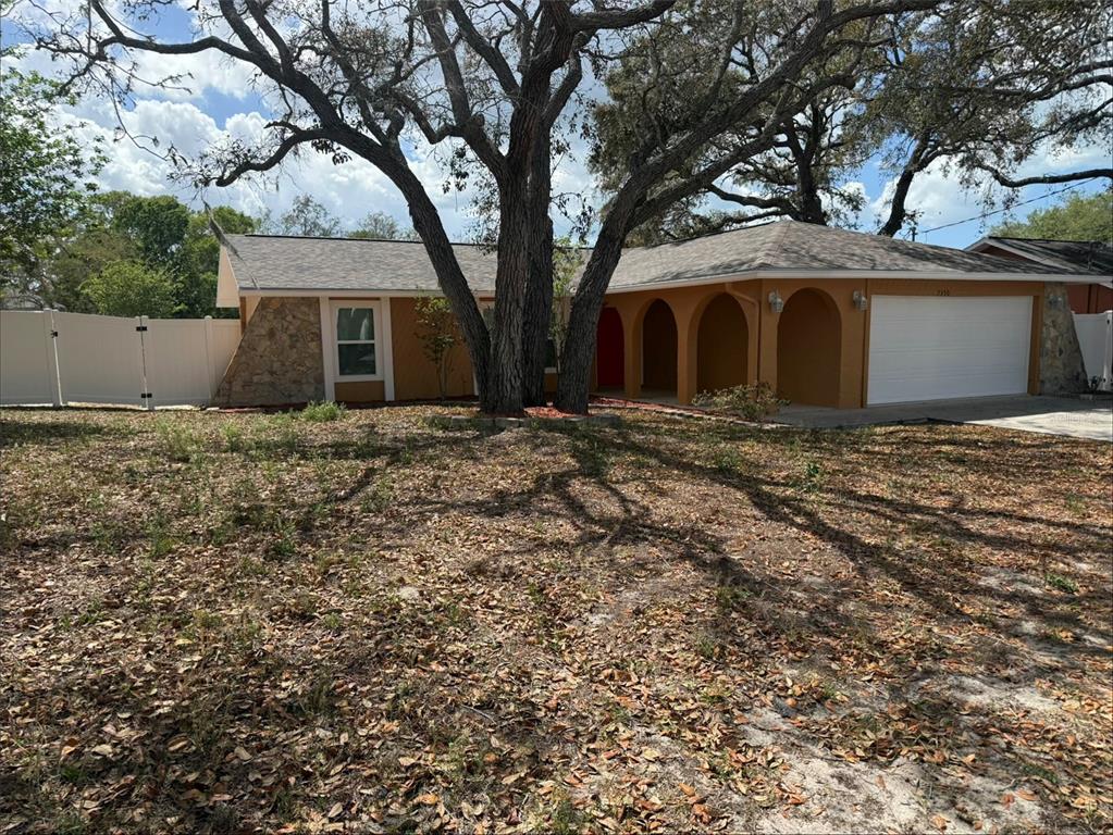 7350 Landmark Drive Spring Hill, FL 34606 - Photo 2 of 16 a large tree in front of a white house