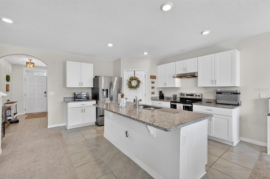 1809 Myrtlebrooke Drive Edgewater, FL 32141 - Photo 12 of 58 a kitchen with white cabinets and white appliances