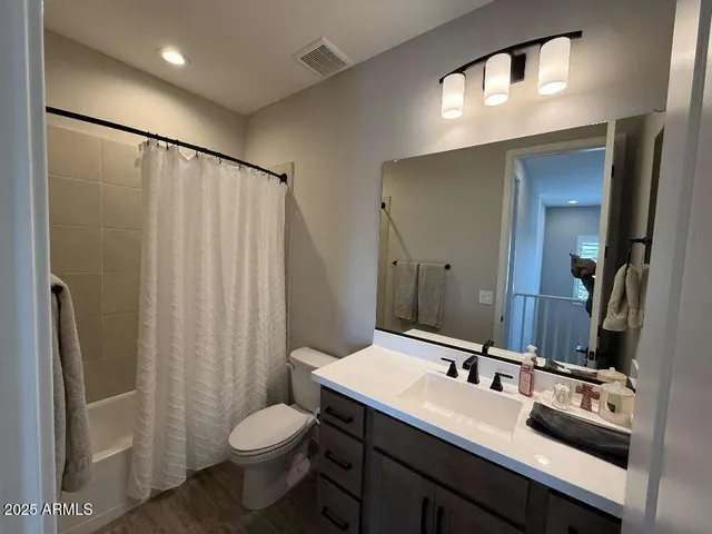 a bathroom with a sink toilet double vanity and shower