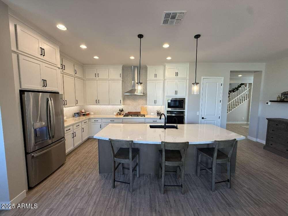 1932 West Rowel Road Phoenix, AZ 85085 - Photo 4 of 24 a kitchen with stainless steel appliances a refrigerator a stove a sink a dining table and chairs with wooden floor
