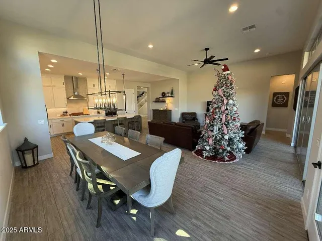 a dining room with furniture a chandelier and wooden floor